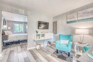 una sala de estar con una silla azul y un dormitorio en Lighthouse Kitchen Suites near Auburn Waterloo I-69 Exit 334, en Auburn