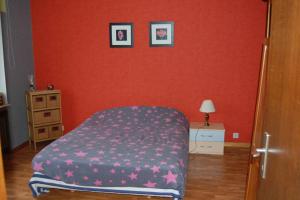 a bedroom with a bed and a red wall at Week-end détente pour 4 personnes in Gouvy