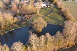 an aerial view of a house and a pond at Week-end détente pour 4 personnes in Gouvy