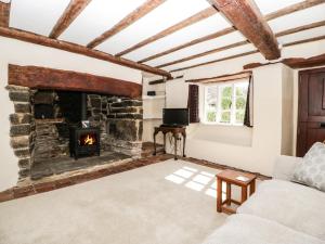 a living room with a stone fireplace at 1 Old Thatch in Bridgwater