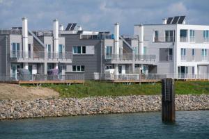 a row of houses on the shore of a body of water at Marina Villa in Kappeln