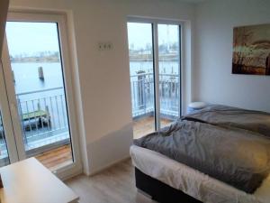 a bedroom with a bed and a balcony at Marina Villa in Kappeln