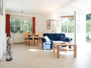 a living room with a blue couch and a table at Kranichrast 1 Whg 2 in Zingst
