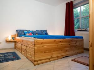 a wooden bed in a room with a window at Kranichrast 1 Whg 2 in Zingst
