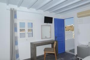 una stanza con una porta blu e un camino di MARKOS BEACH rooms & studios a Mykonos Città