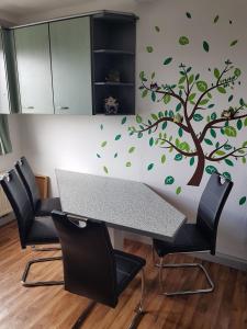 einen Tisch mit einem Baum und grünen Blättern an der Wand in der Unterkunft Ferienwohnung "Am Vaterlandsgrubenweg" - a57586 in Oelsnitz