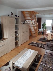 a living room with a staircase and a table at Ferienwohnung "Am Vaterlandsgrubenweg" - a57586 in Oelsnitz