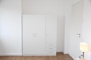 1 dormitorio blanco con armarios blancos en Casa Kronengarten Nr 7, en Hilden