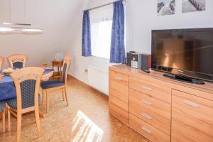 ein Wohnzimmer mit einem Flachbild-TV und einem Esstisch in der Unterkunft Ferienwohnung Schneider in Bannesdorf