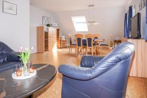 een woonkamer met twee blauwe lederen stoelen en een tafel bij Ferienwohnung Schneider in Bannesdorf