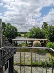 a view from a balcony of a picnic table and a lake at Ferienwohnung zur Forelle - Idyllischer Hof im Grünen in Wester-Ohrstedt