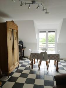 uma sala de jantar com uma mesa e um piso em xadrez em zur Forelle em Wester-Ohrstedt
