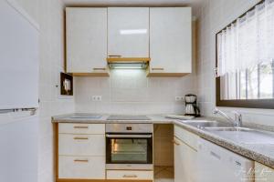 una cocina con armarios blancos y fregadero en Sobre de Granadella Haus 3, en Jávea