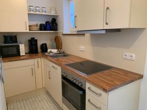 uma cozinha com um lavatório e um fogão forno superior em MPH - Whg 14 em Wyk auf Föhr