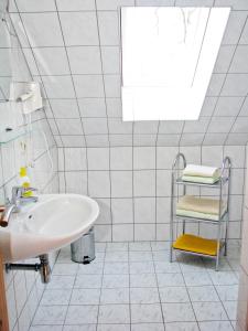 a white bathroom with a sink and a towel rack at Hütigendachs, FW 6 in Zingst