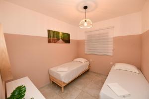 a bedroom with two beds and a lamp at amdar casa in Eilat