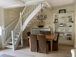 a dining room with a table and a staircase at Deichhof Whg 5 in Dunsum