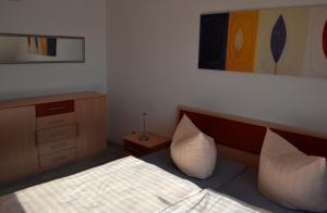 een slaapkamer met een bed met 2 kussens en een kast bij Cantay-Mathildenstraße 16 - FW 4 - OG rechts in Fehmarn