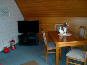 une salle à manger avec une table et une télévision dans l'établissement Haus Monika, à Büdelsdorf