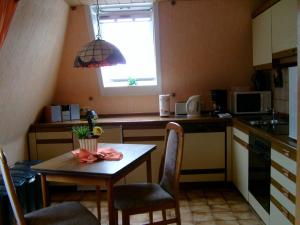 una pequeña cocina con mesa y ventana en Haus Monika en Büdelsdorf