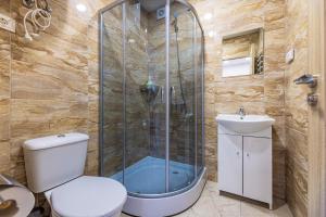 a bathroom with a shower and a toilet and a sink at Poilsio namai Banga Sventojoje in Šventoji