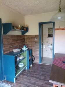 a kitchen with a blue counter and a bathroom at Bakancstanya in Kétbodony