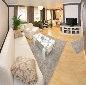 Deluxe Apartments Bremen Typ C في بريمين: غرفة معيشة مع أريكة بيضاء وطاولة