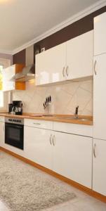 a kitchen with white cabinets and a stove at Deluxe Apartments Bremen Typ C in Bremen