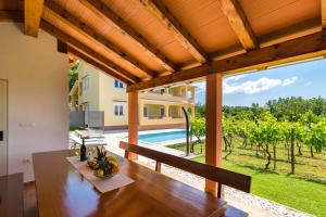 a dining room with a table and a view of a pool at Villa Green Holiday in Barban
