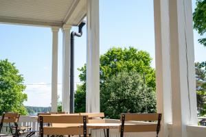 eine Veranda mit einem Tisch, Stühlen und Bäumen in der Unterkunft Boutique Hotel Willa Aria in Savonlinna