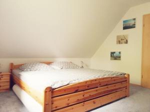 ein Schlafzimmer mit einem Holzbett im Dachgeschoss in der Unterkunft Seerose - 2092 in Bünsdorf