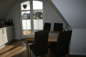 a dining room with a table and chairs and a window at Whg 17 - De Mügg in Zingst