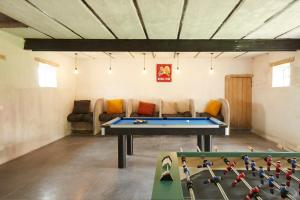 a room with a ping pong table and a couch at Het Klaverhof in Haringe