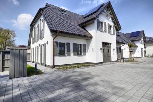 a white house with a black roof at Sanya in Zingst