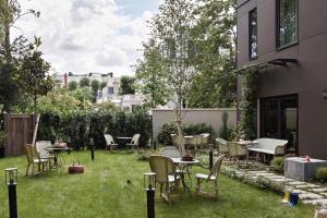 a patio with chairs and tables on the grass at Hôtel Botaniste in Paris