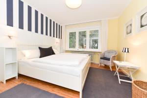 ヴィーク・アウフ・フェールにあるHaus Nordseegartenのベッドルーム(大きな白いベッド1台、椅子付)