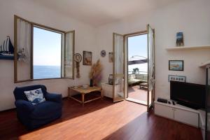 uma sala de estar com uma cadeira azul e uma televisão em Villa Lardarina em Corniglia