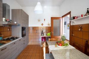 uma cozinha com armários de madeira e uma tigela de fruta no balcão em Villa Lardarina em Corniglia