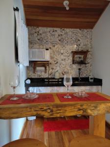 a kitchen with two wine glasses on a wooden table at Chalés Vale das Pedras in Venda Nova do Imigrante +16 photos