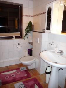 a white bathroom with a sink and a toilet at Ferienwohnung PANTEN in Neukirchen