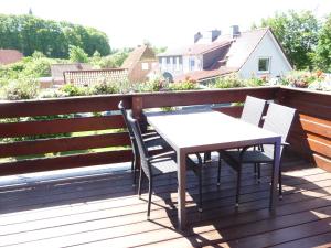 Biały stół i krzesła na drewnianym tarasie w obiekcie Ferienwohnung PANTEN w mieście Neukirchen