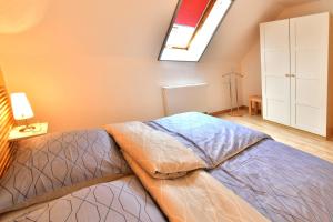 a bedroom with a bed and a skylight at Haus am Hafen Boddenzauber FW 4 in Zingst