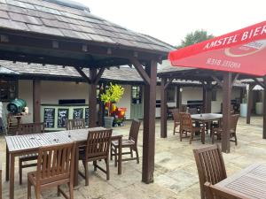 a restaurant with tables and chairs and a red umbrella at The Bickerton Poacher in Higher Burwardsley