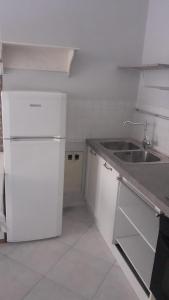 cocina blanca con fregadero y nevera en Bergamo City Apartments, en Bérgamo