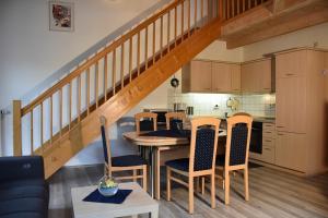 a kitchen with a table and chairs and a staircase at Ferienhaus Nr 6A2, Feriendorf Hagbügerl, Bayr Wald in Waldmünchen