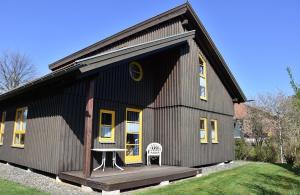 a black house with a porch and a table and chairs at Ferienhaus Nr 6A2, Feriendorf Hagbügerl, Bayr Wald in Waldmünchen