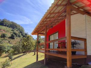 una decoración de una casa con techo rojo en Chalés Vale das Pedras en Venda Nova do Imigrante