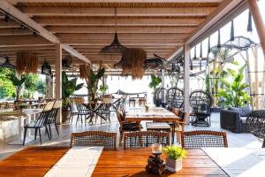 restauracja z drewnianymi stołami i krzesłami oraz stolarką w obiekcie Blue Carpet Luxury Suites w mieście Pefkochori
