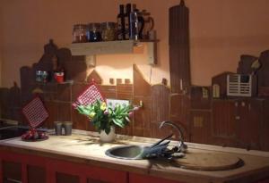 a kitchen counter with a sink and a vase of flowers at Fewo kerzenzimmer in Kirch Mulsow