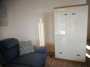 Komfort-Wohnung 03 FehmarnBrise في بورغ أوف فيهمارن: غرفة معيشة مع أريكة زرقاء وخزانة